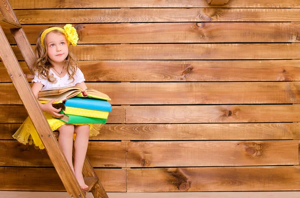 Niña con pila de libros sentada en la escalera — Foto de Stock