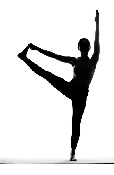 Silhouette einer Frau, die Yoga-Übungen macht — Stockfoto
