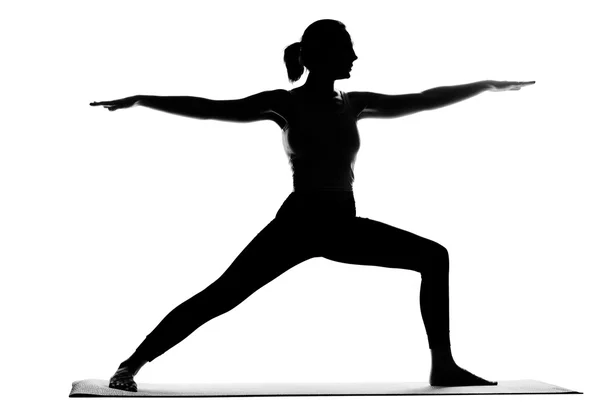 Silueta de mujer practicando ejercicios de yoga —  Fotos de Stock