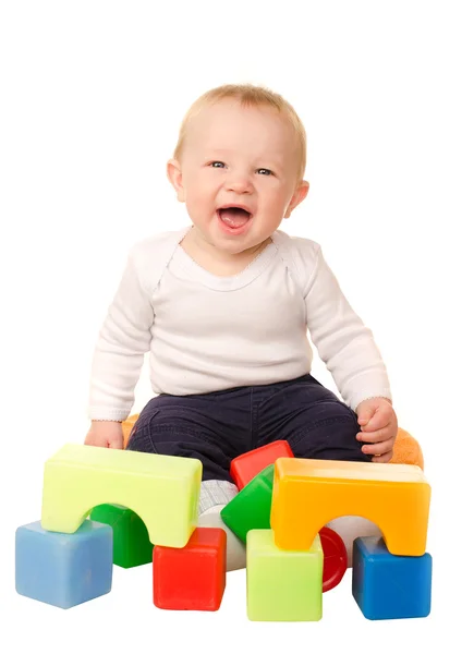 Fröhlicher kleiner Junge spielt mit bunten Blöcken — Stockfoto