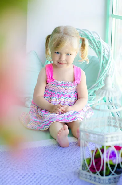 Little cute girl sitting near window — Stock Photo, Image