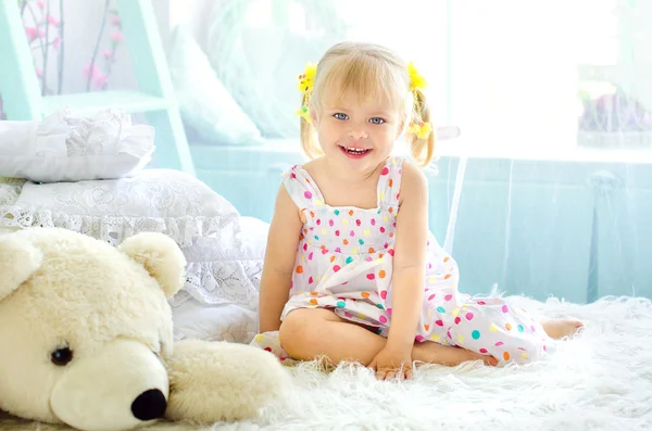 Niña en dormitorio de luz con gran oso de peluche blanco —  Fotos de Stock