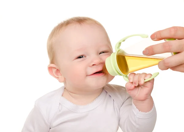 Divertido bebé niño bebiendo de biberón Imagen de archivo