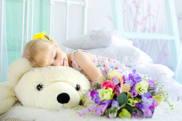 Holčička s květinami, zahrnující velký plyšový medvěd Stock Snímky