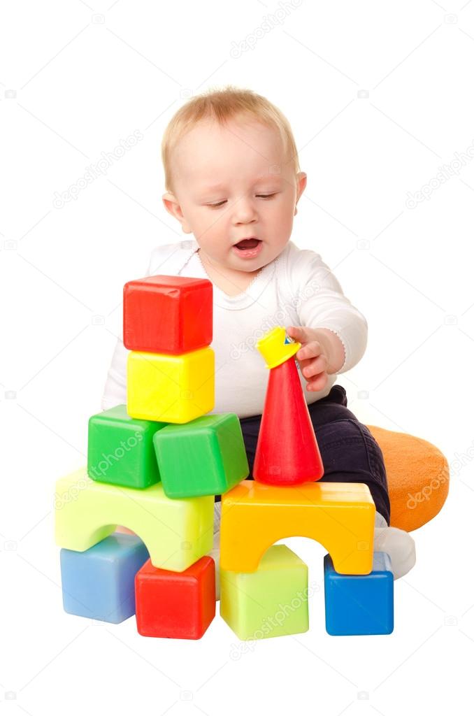 cheerful baby boy playing with colorful blocks