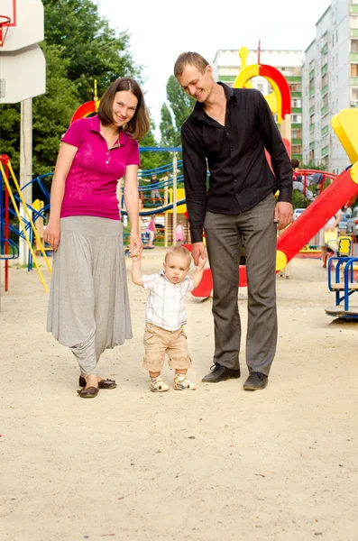 Papi, mami e hijo pequeño en el patio de recreo —  Fotos de Stock