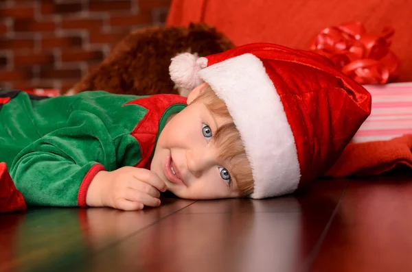 Lying little boy in festive attire indoors — Stock Photo, Image