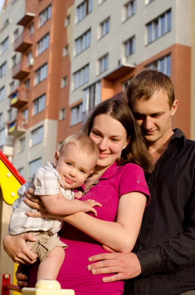 Familia joven abrazándose en la ciudad al aire libre Imagen de archivo