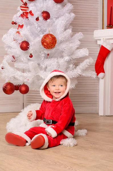 Niño en traje festivo en el árbol de Navidad Fotos de stock libres de derechos