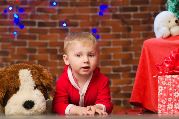 Menino em vermelho com cachorro de brinquedo macio — Fotografia de Stock