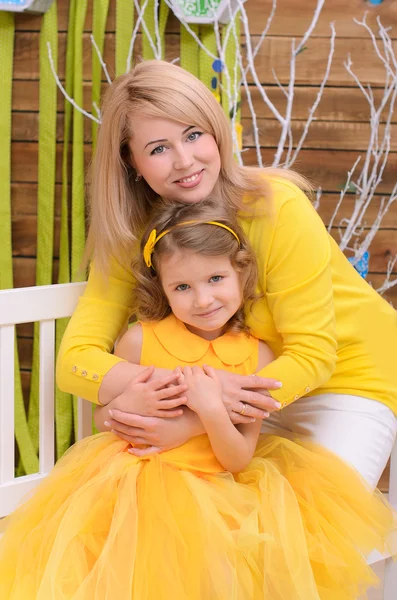 Mother and daughter in yellow indoors — Stock Photo, Image