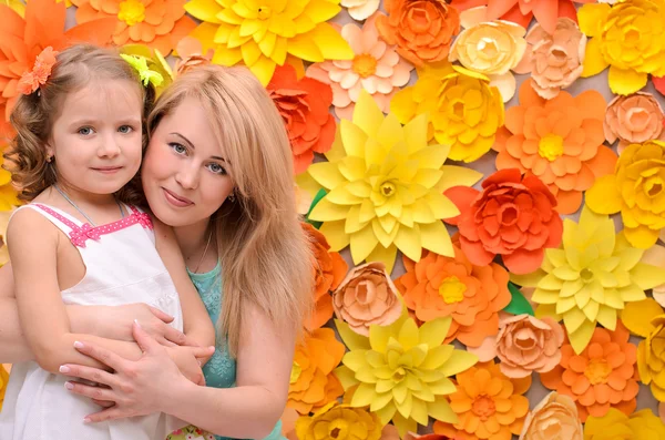 Mama en dochter op bloemen achtergrond — Stockfoto