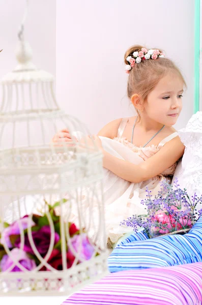 Little girl with birdcage in home interior — Stock Photo, Image
