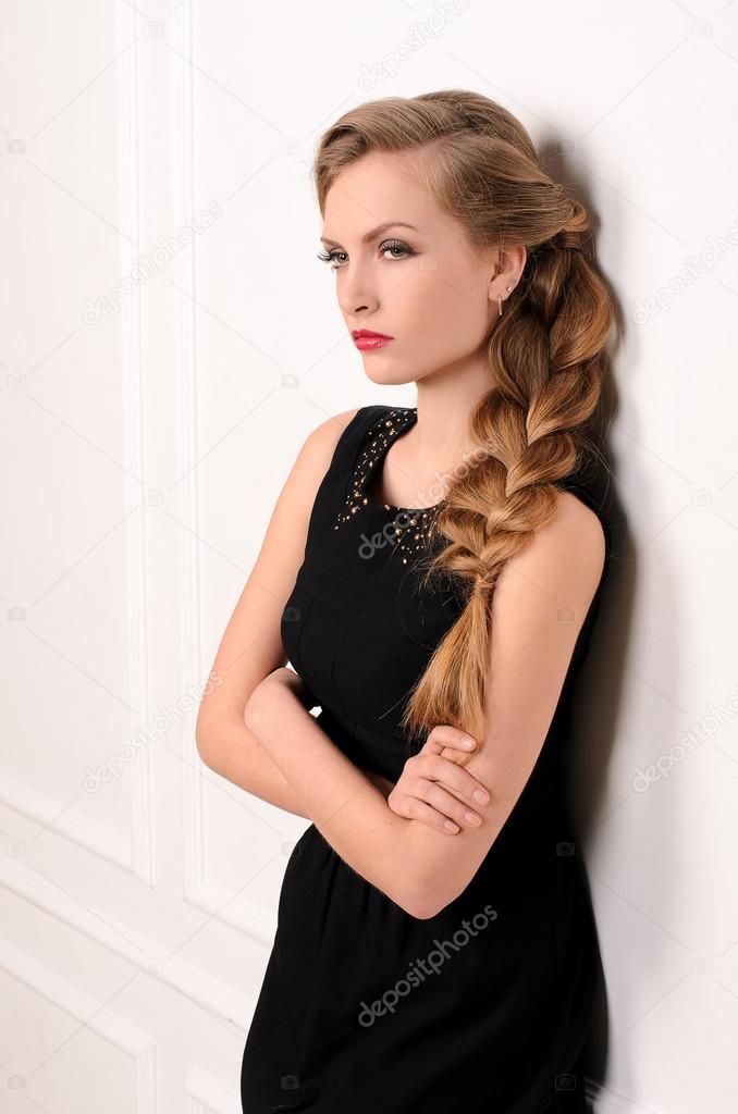 young woman in black gown on white wall