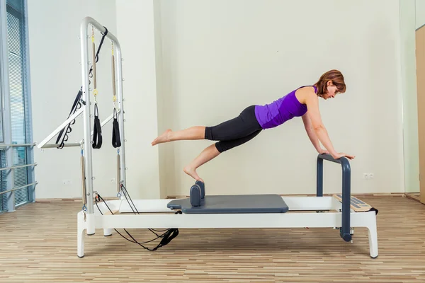 Μελαχρινή γυναίκα ασκήσεις pilates αναμορφωτήρα προπόνηση στο γυμναστήριο και εσωτερική — Φωτογραφία Αρχείου