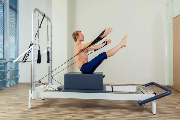Pilates αναμορφωτήρα προπόνηση άνθρωπος ασκήσεις στο γυμναστήριο και εσωτερική. — Φωτογραφία Αρχείου