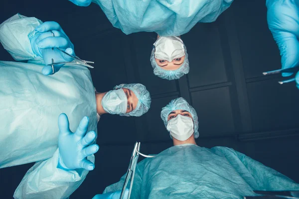 Медицинская бригада проводит операцию. Группа хирургов за работой в операционной. здравоохранение  . — стоковое фото