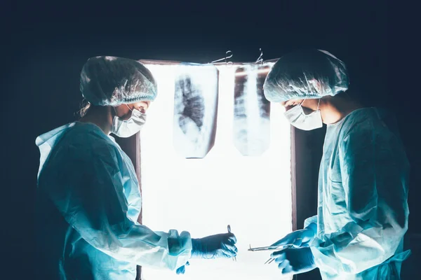 Dos cirujanos trabajando y concentrándose en la mesa de operaciones —  Fotos de Stock