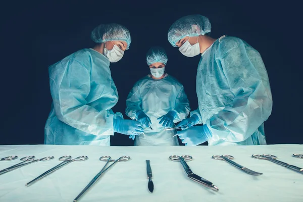 Medical team  hospital performing operation. Group of surgeon at work in operating theatre room. healthcare . — Zdjęcie stockowe