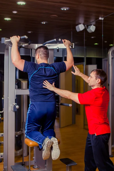 Deporte, fitness, trabajo en equipo, culturismo concepto de personas - hombre y entrenador personal con barra de pesas grupo de levantamiento de pesas entrenamiento gimnasio . —  Fotos de Stock