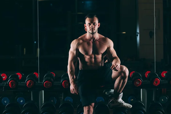 Musculoso hombre fuera en el gimnasio de pie cerca de pesas, fuerte macho desnudo torso abs —  Fotos de Stock