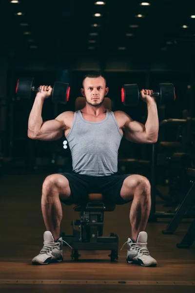 Spor, vücut geliştirme, halter, yaşam tarzı ve insanlar kavramı - jimnastik salonu kas esneme dumbbells ile genç adam — Stok fotoğraf