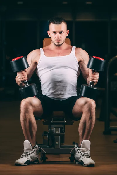 Sport, bodybuilding, weightlifting, lifestyle and people concept - young man with dumbbells flexing muscles in gym — Stock Photo, Image