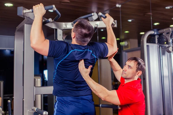 Sport, fitness, pracy zespołowej, koncepcja ludzie Kulturystyka - człowiek i osobisty trener z grupy ćwiczenie sztangą podnoszenie ciężarów ćwiczeń siłownia. — Zdjęcie stockowe