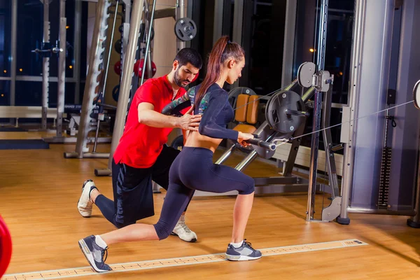 Fitness, deporte, entrenamiento y concepto de personas - Entrenador personal que ayuda a las mujeres que trabajan en el gimnasio — Foto de Stock