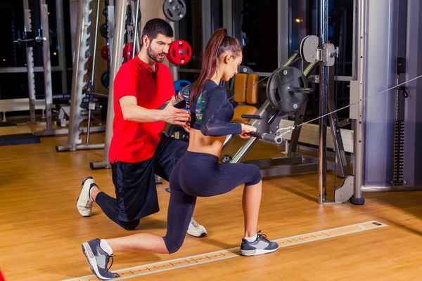 Fitness, sport, výcvik a lidé koncept - osobní trenér pomáhá žena pracující se v tělocvičně — Stock fotografie