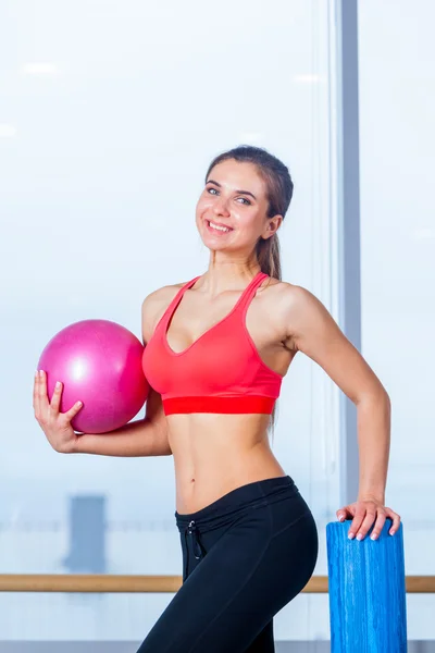 Красива атлетична талія молодої дівчини з рожевим м'ячем в руці спортзал — стокове фото