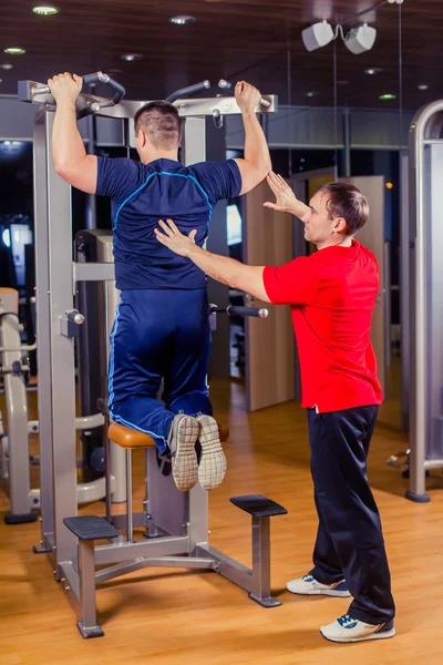 Deporte, fitness, trabajo en equipo, culturismo concepto de personas - hombre y entrenador personal con barra de pesas grupo de levantamiento de pesas entrenamiento gimnasio . — Foto de Stock
