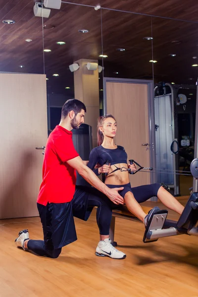 Personal Trainer arbeitet mit seinem Klienten im Fitnessstudio — Stockfoto