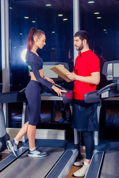 Personal Trainer hilft Frau beim Arbeiten mit Laufband — Stockfoto