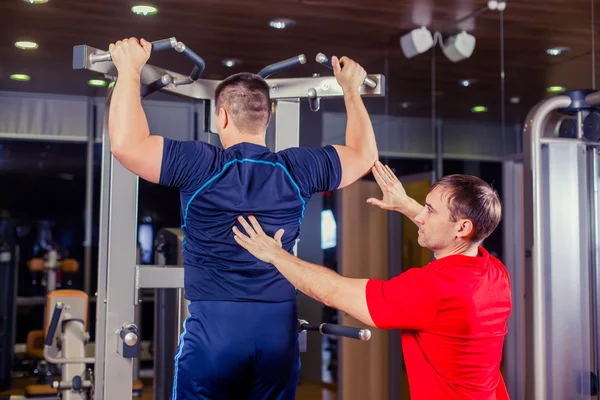 Esporte, fitness, trabalho em equipe, musculação conceito pessoas homem e personal trainer com barra de levantamento de peso grupo musculação exercício ginásio . — Fotografia de Stock