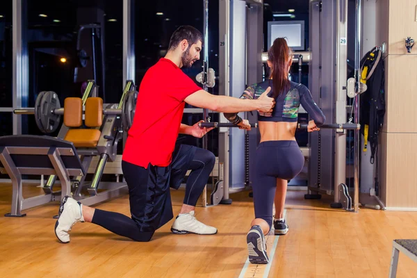 Fitness, sport, allenamento e concetto di persone - Personal trainer che aiuta la donna a lavorare con in palestra — Foto Stock