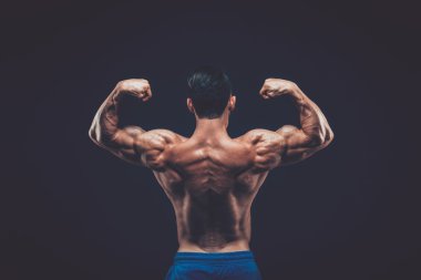 Kaslı adam siyah arka plan üzerinde koyu Studio poz.