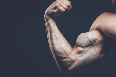 Atlet güzel vücudu siyah arka plan üzerinde gösterir..