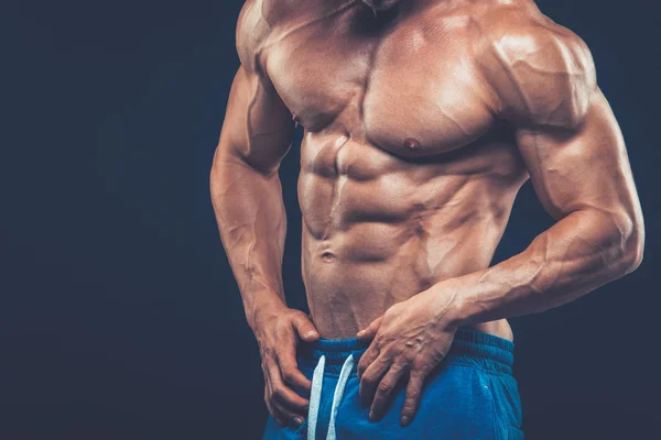 Strong athletic man on black background — Stock Photo, Image