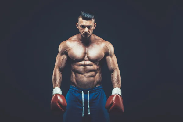 Muscular boxer in studio shooting, on black background. — Stock Photo, Image