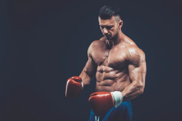 Boxeador muscular en rodaje de estudio, sobre fondo negro . — Foto de Stock