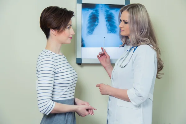 Médico explicando el diagnóstico a su paciente mujer analizando la fotografía de rayos X — Foto de Stock