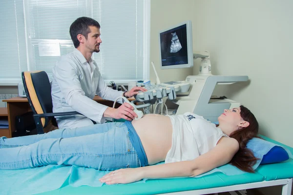 Pregnant woman laying on the couch during ultrasound checking — Stock Photo, Image