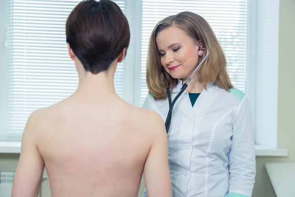 Läkaren lyssnar på patienter bröstet med stetoskop på hans kontor på sjukhuset — Stockfoto