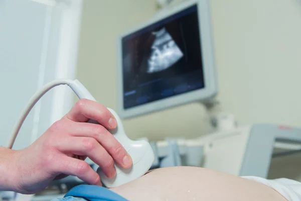 Pregnant woman laying on the couch during ultrasound checking — Stock Photo, Image