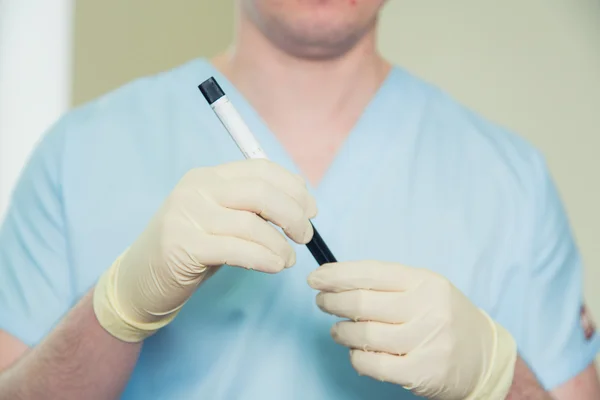 Mão de um médico segurando amostra de sangue do frasco — Fotografia de Stock