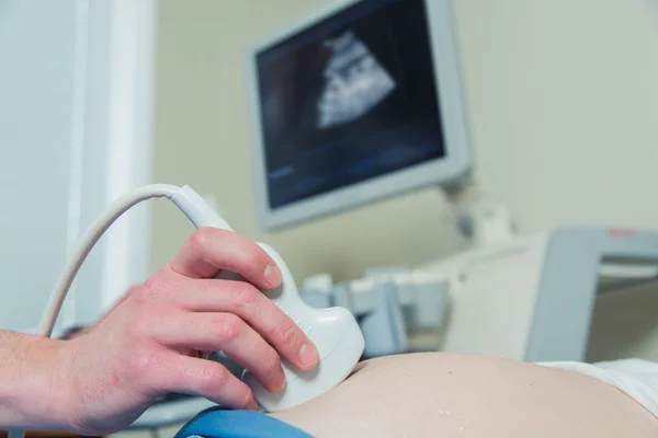Pregnant woman laying on the couch during ultrasound checking — Stock Photo, Image