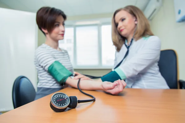 Healthcare, hospital medicine concept - doctor and patient measuring blood pressure Stock Image