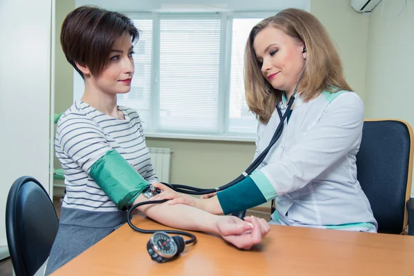 Healthcare, hospital medicine concept - doctor and patient measuring blood pressure Stock Picture