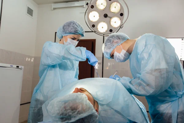 Equipo de cirujanos trabajando con monitorización del paciente en quirófano . —  Fotos de Stock